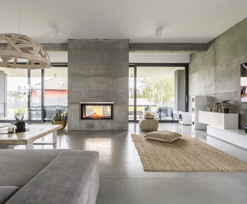 Spacious villa interior with cement wall effect, fireplace and tv